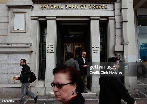 People pass by a branch of the National Bank of Greece on March 24, 2010 in Athens, Greece. Fellow European nations negotiated on March 24 over what...