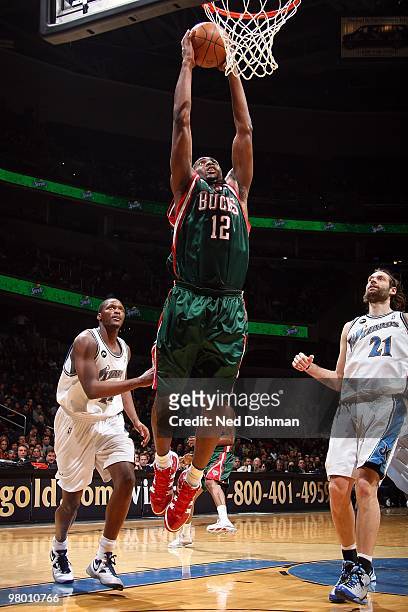 Luc Mbah a Moute of the Milwaukee Bucks goes to the basket as Al Thornton and Fabricio Oberto of the Washington Wizards look on during the game on...