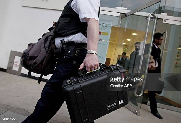 Police officer leaves the London office of French engineering group Alstom, on March 24, 2010. Three members of the board of French engineering group...