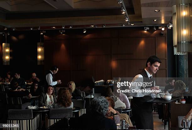 Waiters serve customers in a fashionable restaurant on March 24, 2010 in Athens, Greece. Luxury goods and brands have made their way to...