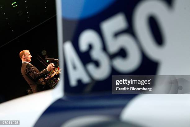 Tom Enders, chief executive officer of Airbus SAS, speaks from behind a model Airbus A350 jet at an air travel technology exhibition in Berlin,...