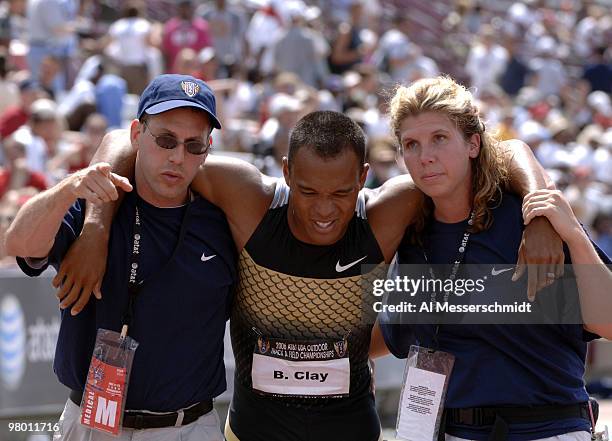 Bryan Clay is carried from the track after the 400 meters in first-day men's decathlon competition June 23 at the 2006 AT&T Outdoor Track and Field...