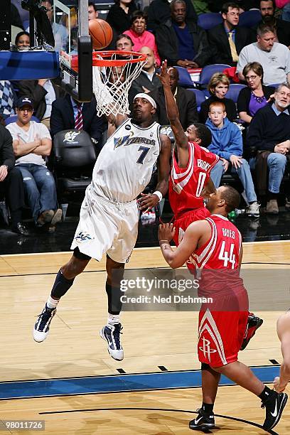 Andray Blatche of the Washington Wizards goes to the basket against Aaron Brooks and Chuck Hayes of the Houston Rockets during the game on March 9,...