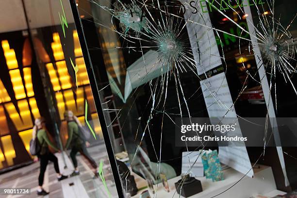 Broken windows from recent rioting protesting government financial austerity measures are seen at a department store on March 24, 2010 in central...