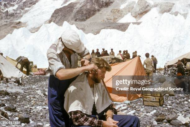 Charles Evans cutting George Lowe's hair at Base Camp, Nepal, March 1953. Mount Everest Expedition 1953.