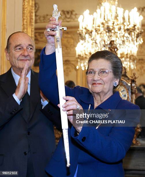 French politician Simone Veil stands with former president Jacques Chirac as she displays her ceremonial epee she received as a new member of the...