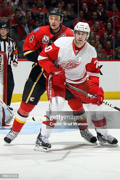 Jay Bouwmeester of the Calgary Flames skates against Drew Miller of the Detroit Red Wings on March 15, 2010 at Pengrowth Saddledome in Calgary,...