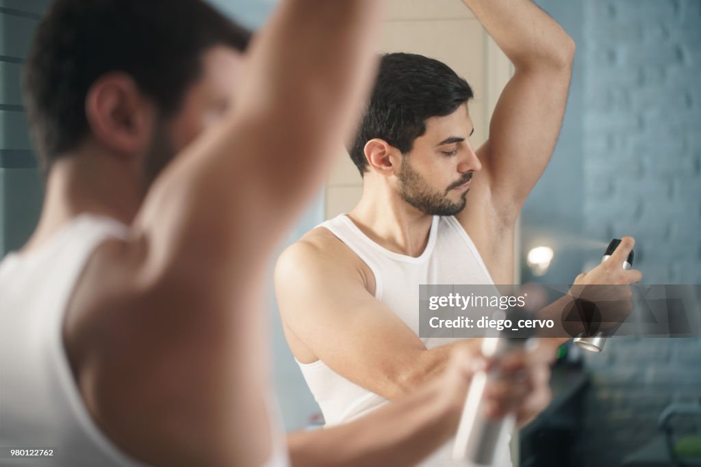 Hombre usando Spray desodorante en las axilas para el mal olor