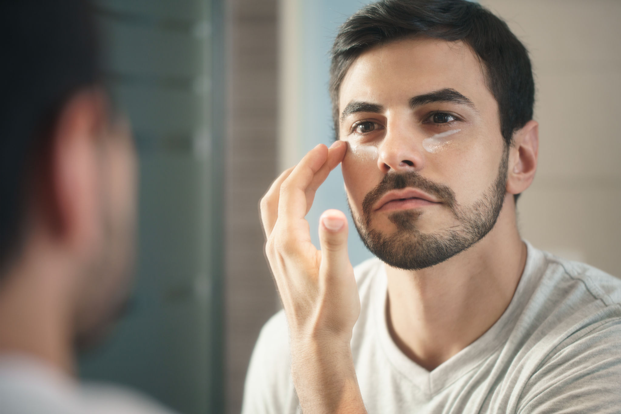Young Man Applying Anti-aging Lotion fot Skin Care Young Man Applying Anti-aging Lotion fot Skin Care