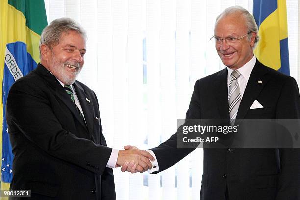 Brazilian President Luiz Inacio Lula da Silva and Sweden's King Carl Gustaf shake hands at the Itamaraty Palace in Brasilia, on March 24, 2010. King...