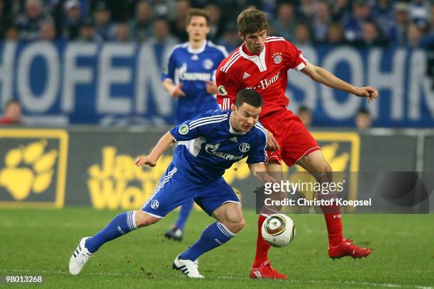 Thomas Mueller of Bayern challenges Alexander Baumjohann of Schalke during the DFB Cup semi final match between FC Schalke 04 and FC Bayern Muenchen...