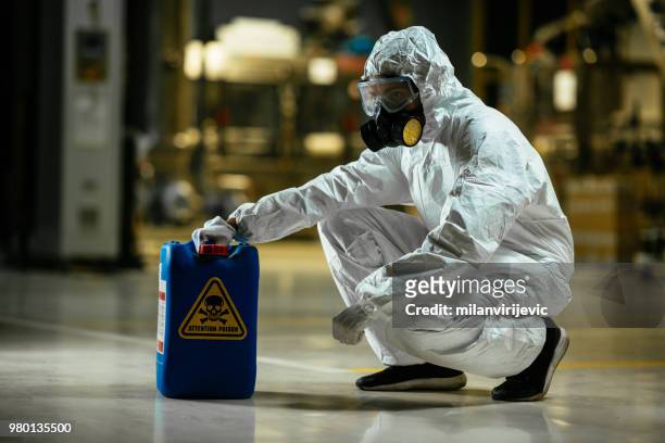 factory worker wearing gas mask and radioactive protection suit - toxic substance stock pictures, royalty-free photos & images