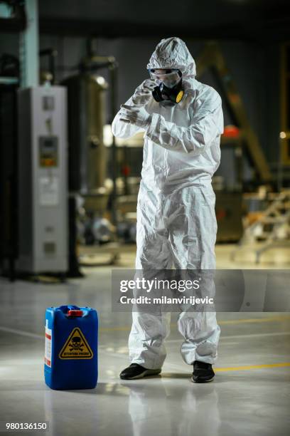 obrero trabajando con materiales peligrosos - traje nuclear fotografías e imágenes de stock