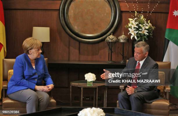 Jordanian King Abdullah II talks to German Chancellor Angela Merkel at the Jordanian Royal Palace in Amman on June 21, 2018.