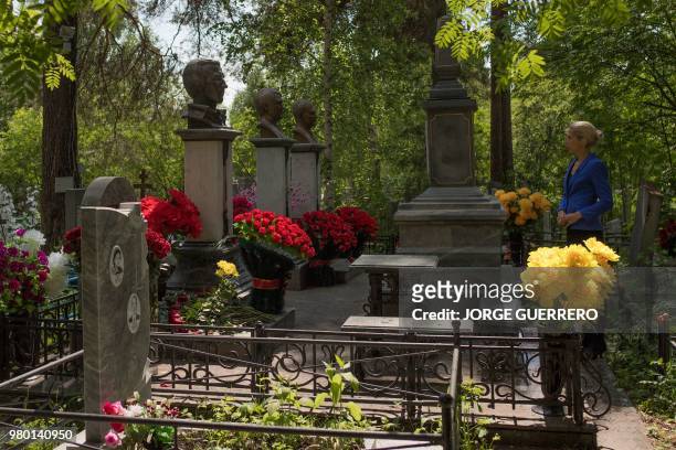 This picture taken on June 19, 2018 shows Mary Tretjak, a Yekaterinburg native and expert in the city's history, looking at the tombstones of former...