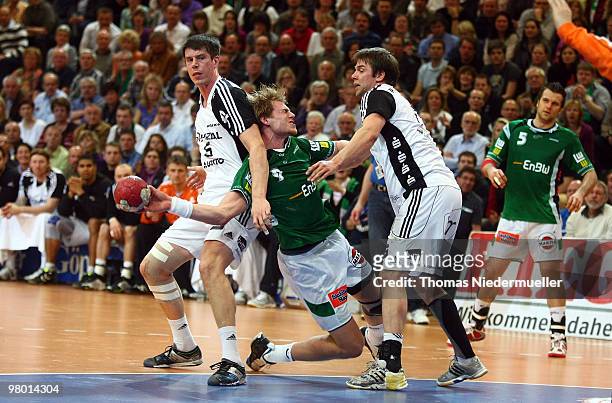 Manuel Spaeth of Goeppingen fights for the ball with Kim Andersson and Christian Sprenger of Kiel during the Handball Bundesliga match between Frisch...
