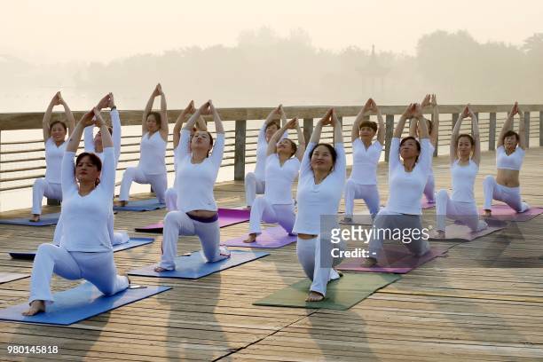 People attend a yoga session to mark International Yoga Day in Huaibei in China's eastern Anhui province on June 21, 2018. / China OUT