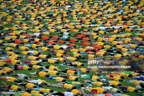 Yoga enthusiasts perform yoga to mark International Yoga Day at the Sri Kanteerava Stadium in Bangalore on June 21, 2018. - Downward-facing dogs,...