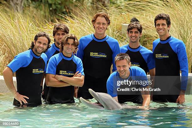 Dick Norman, Marcelo Melo, Thomas Bellucci, Fernando Gonzalez, Robin Soderling, David Ferrer and Eduardo Schwank pose with a dolphin during day two...