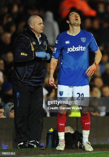 Tommy Smith of Portsmouth is helped from the pitch after a clash with Daniel Sturridge of Chelsea during the Barclays Premier League match between...