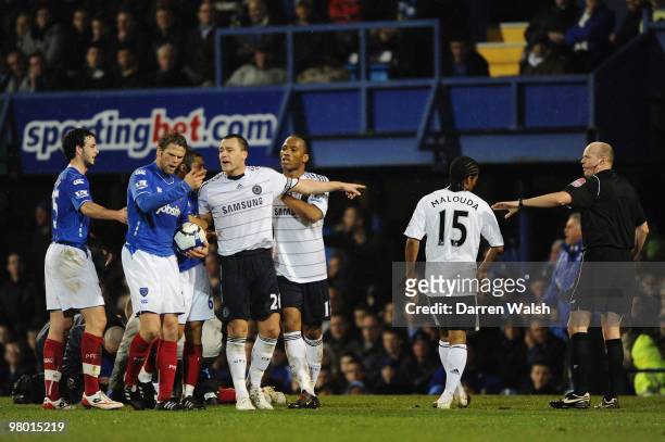 Ricardo Rocha of Portsmouth lies injured on the pitch after a clash with Florent Malouda of Chelsea as John Terry argues with the POrtsmouth players...