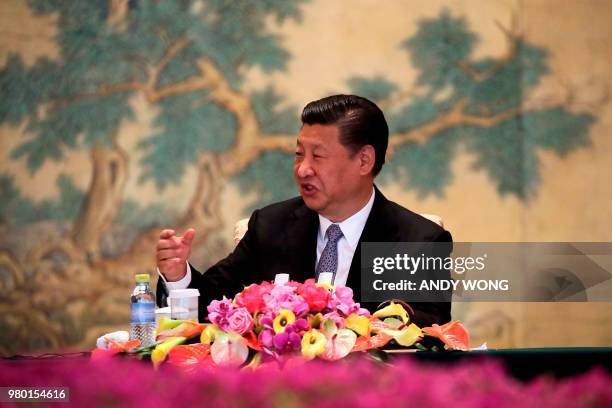 Chinese President Xi Jinping gestures as he delivers his opening remarks to members of a global chief executive committee at the Diaoyutai State...