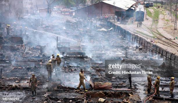 Fire fighters douse flames at a slum cluster near Sadar Bazar where a major fire broke out, on June 14, 2008 in New Delhi, India.