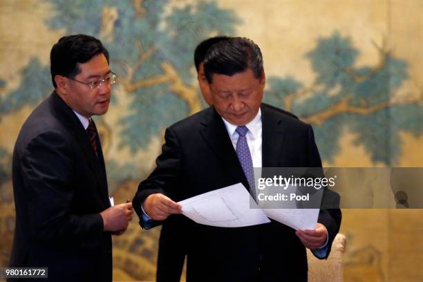 Chinese President Xi Jinping looks at the documents as he arrives for the round table summit with members of Global chief executive committee at the...