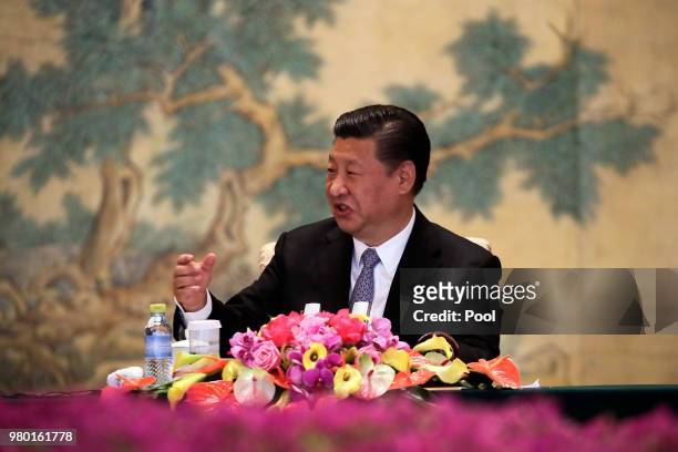 Chinese President Xi Jinping gestures as he delivers his opening remarks to the members of Global chief executive committee during the round table...
