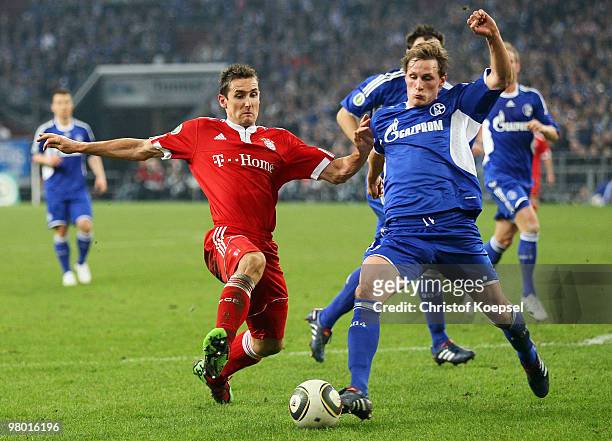 Benedikt Hoewedes of Schalke challenges Miroslav Klose of Bayern during the DFB Cup semi final match between FC Schalke 04 and FC Bayern Muenchen at...