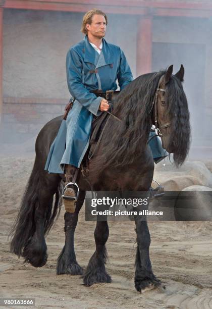 June 2018, Germany, Ralswiek: Alexander Koll as Pirate Klaus Stoertebeker riding a horse on the island Ruegen at the outdoor stage Ralswiek for the...