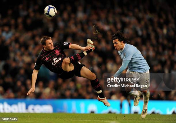Phil Jagielka of Everton challenges Carlos Tevez of Manchester City during the Barclays Premiership match between Manchester City and Everton at the...