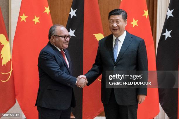 Papua New Guinea's Prime Minister Peter O'Neill shakes hands with China's President Xi Jinping at the Diaoyutai State Guesthouse in Beijing on June...