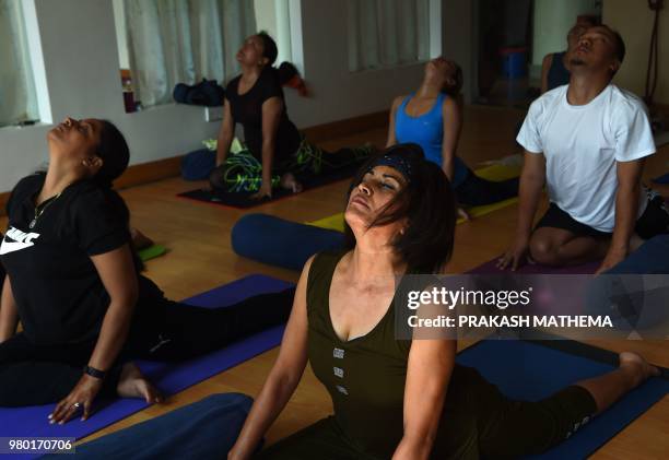 Nepali yoga practitioners take part in a yoga session class on the International Yoga Day in Kathmandu on June 21, 2018. - Downward-facing dogs,...