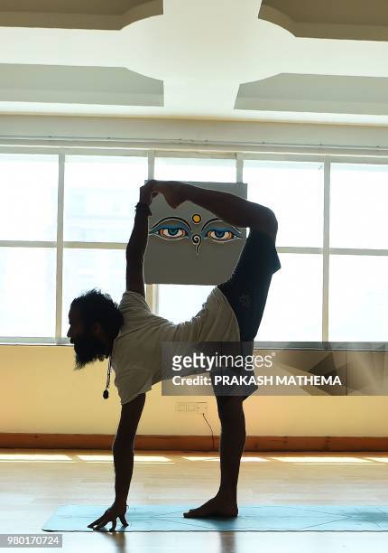 Nepali yoga practitioner takes part in a yoga session class on the International Yoga Day in Kathmandu on June 21, 2018. - Downward-facing dogs,...