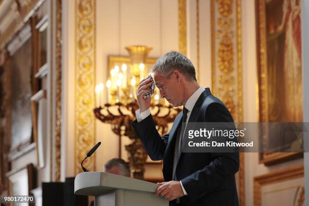 The General Secretary Of NATO Jens Stoltenberg wipes his brow as he delivers his pre-summit speech at Lancaster House on June 21, 2018 in London,...