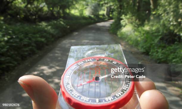 compass being used on country lane - navigational equipment stock pictures, royalty-free photos & images