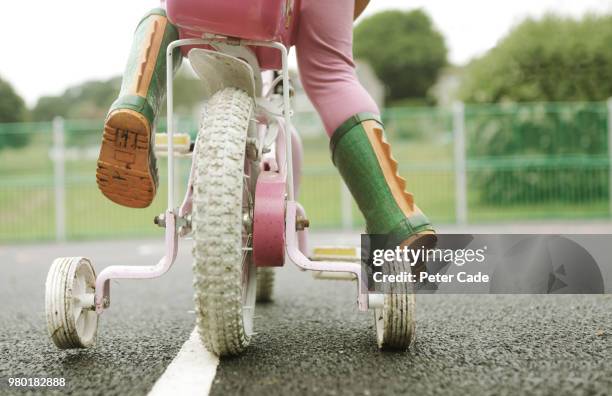 toddler on bicycle with stabilizers - evolution concept stock pictures, royalty-free photos & images