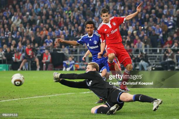 Goalkeeper Manuel Neuer of Schalke saves a ball against Miroslav Klose of Munich and Joel Matip of Schalke during the DFB Cup semi final match...