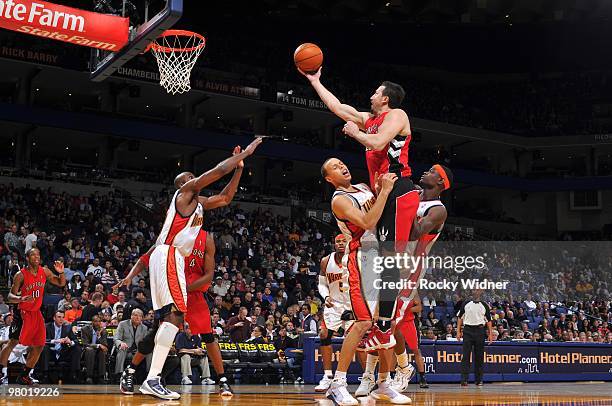 Hedo Turkoglu of the Toronto Raptors shoots a layup over Stephen Curry and Anthony Morrow of the Golden State Warriors during the game at Oracle...