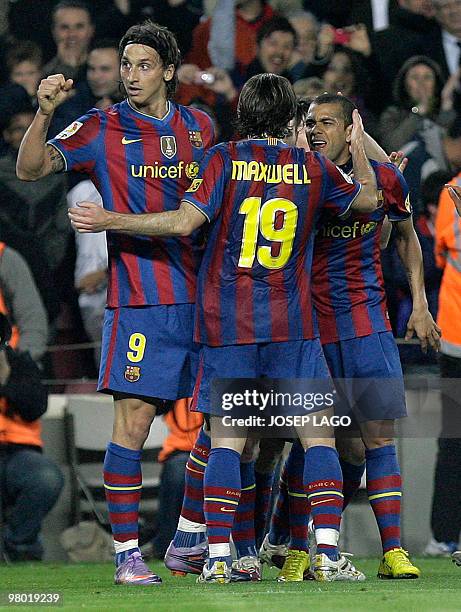 Barcelonas's Swedish forward Zlatan Ibrahimovic is congratuled by his teamates Brazilian defender Maxwell and Brazilian defender Daniel Alves after...