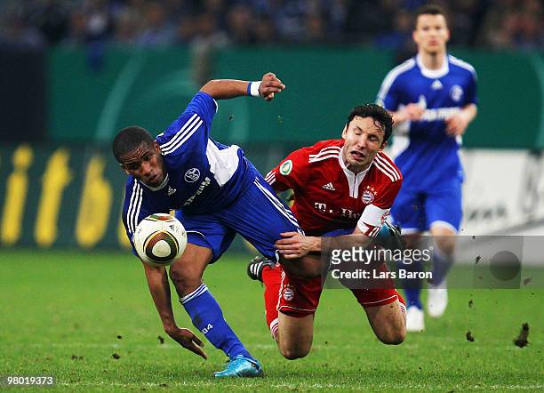 Jefferson Farfan of Schalke is challenged by Mark van Bommel of Muenchen during the DFB Cup semi final match between FC Schalke 04 and FC Bayern...