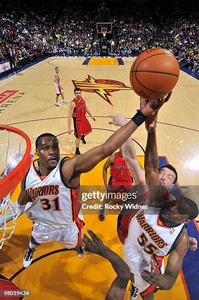 Chris Hunter and Reggie Williams of the Golden State Warriors rebounds against Hedo Turkoglu of the Toronto Raptors during the game at Oracle Arena...