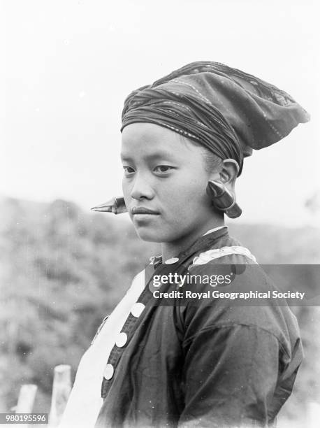 Kachin woman in her gala dress, Accompanying caption: 'Kachins or Chingpaw and Maru of Burma. Another Kachin woman in her gala dress. The ear lobes...