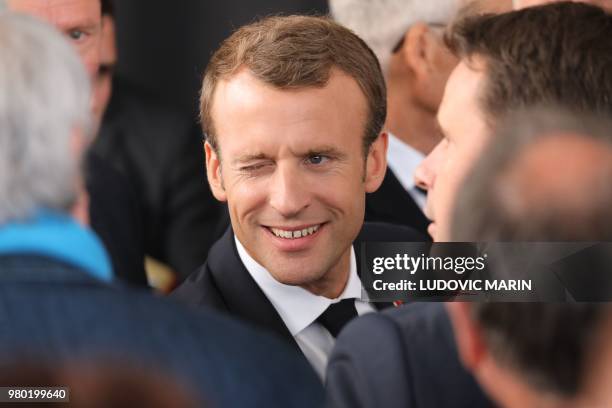 French President Emmanuel Macron winks an eye as he meets people after giving a speech on June 21 during his visit at the French western France of...