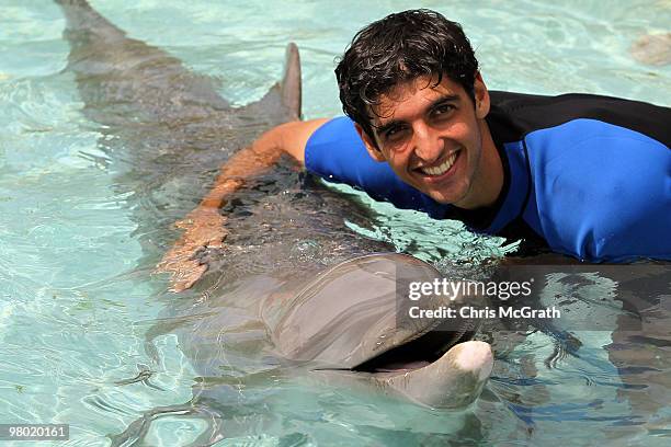 Thomas Bellucci poses with a dolphin during day two of the 2010 Sony Ericsson Open at Miami Seaquarium on March 24, 2010 in Key Biscayne, Florida.