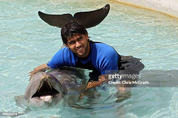 Eduardo Schwank poses with a dolphin during day two of the 2010 Sony Ericsson Open at Miami Seaquarium on March 24, 2010 in Key Biscayne, Florida.