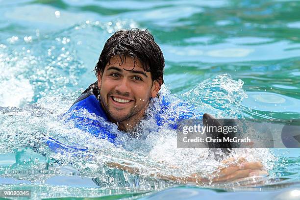 Eduardo Schwank swims with a dolphin during day two of the 2010 Sony Ericsson Open at Miami Seaquarium on March 24, 2010 in Key Biscayne, Florida.