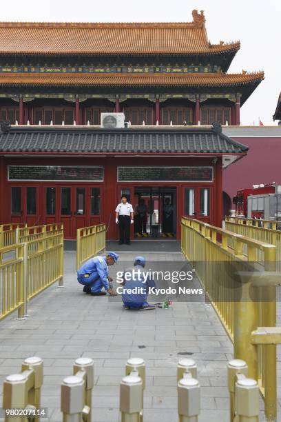 Workers clean near the admission gate of the Tiananmen Tower in Beijing on June 15, 2018. Chinese authorities made the Tiananmen Tower off-limits the...