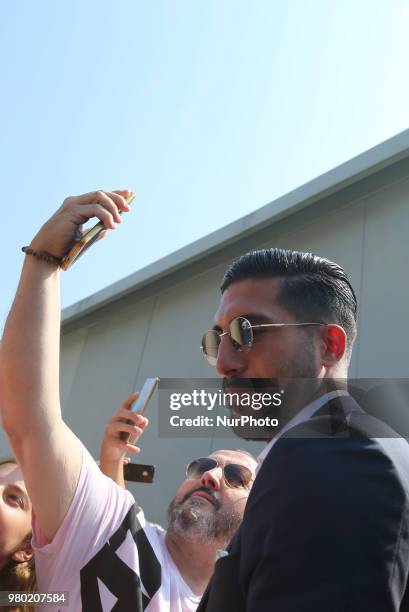 New Juventus signing Emre Can poses for a selfie with his fan Efollowing his arrival in Turin on June 21, 2018 in Turin, Italy.